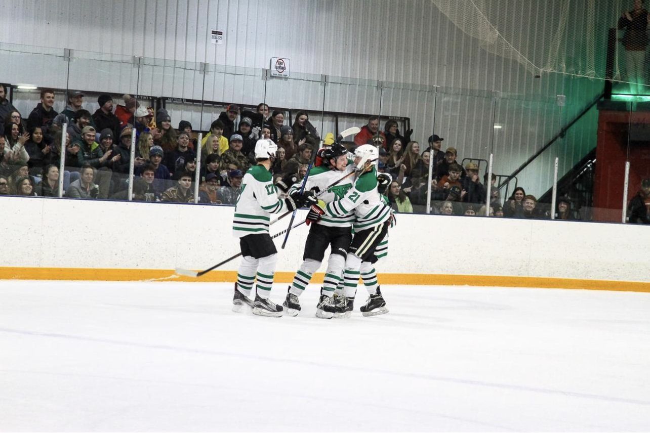 Montana Tech celebrates a goal in front of a huge crowd at the Butte Community Ice Center Pictured: Max Triepke and Brad Rutherford embracing Nolan Samples (Photo: BnO Photography)